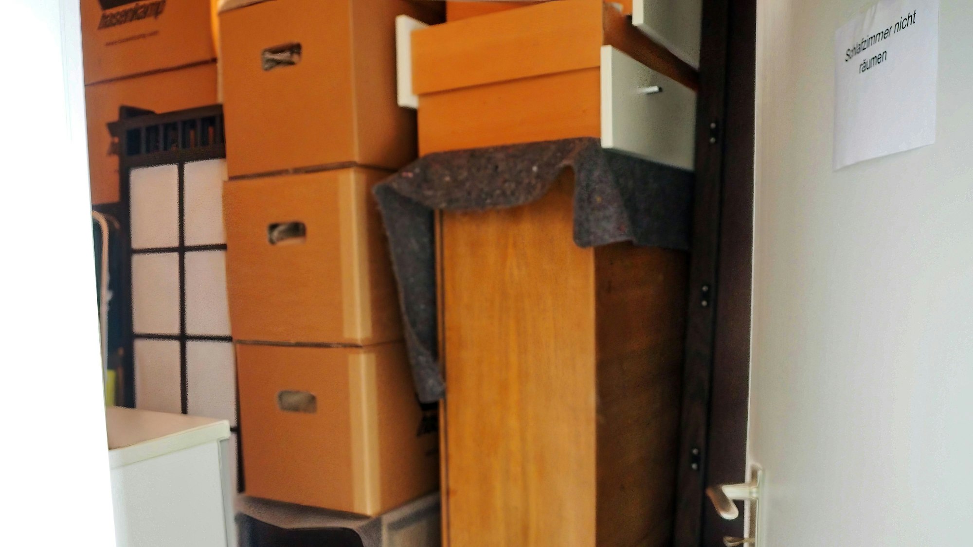 Im Schlafzimmer stapeln sich Möbel und Kartons. Nur durch einen schmalen Pfad kann Susanne Hönig an ihren Kleiderschrank kommen.