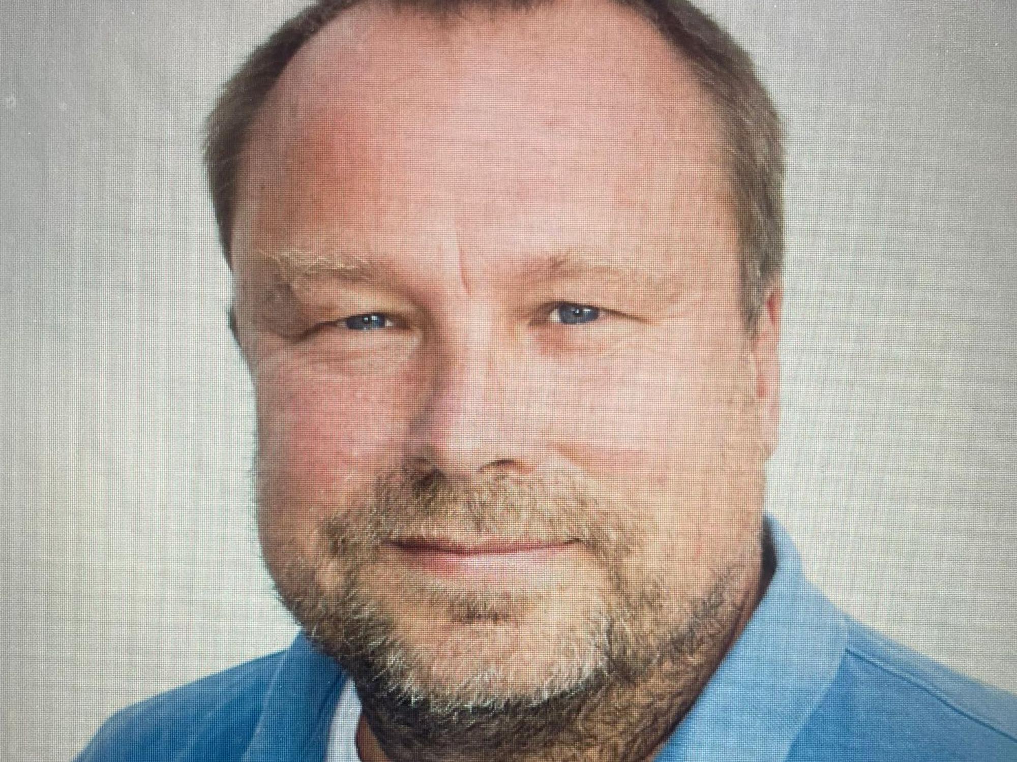 Ein Mann mit Bart und blauem Hemd.