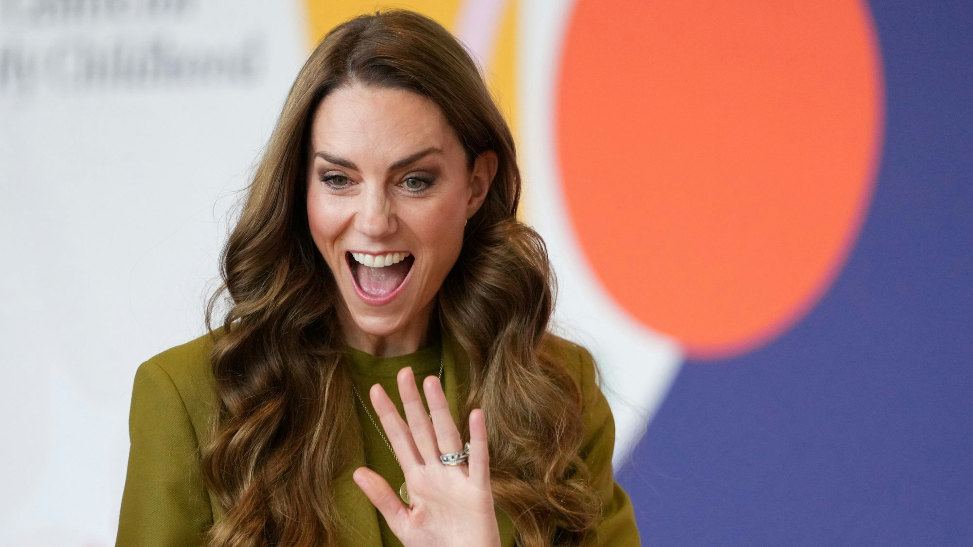 Prinzessin Kate winkt und reißt den Mund auf.