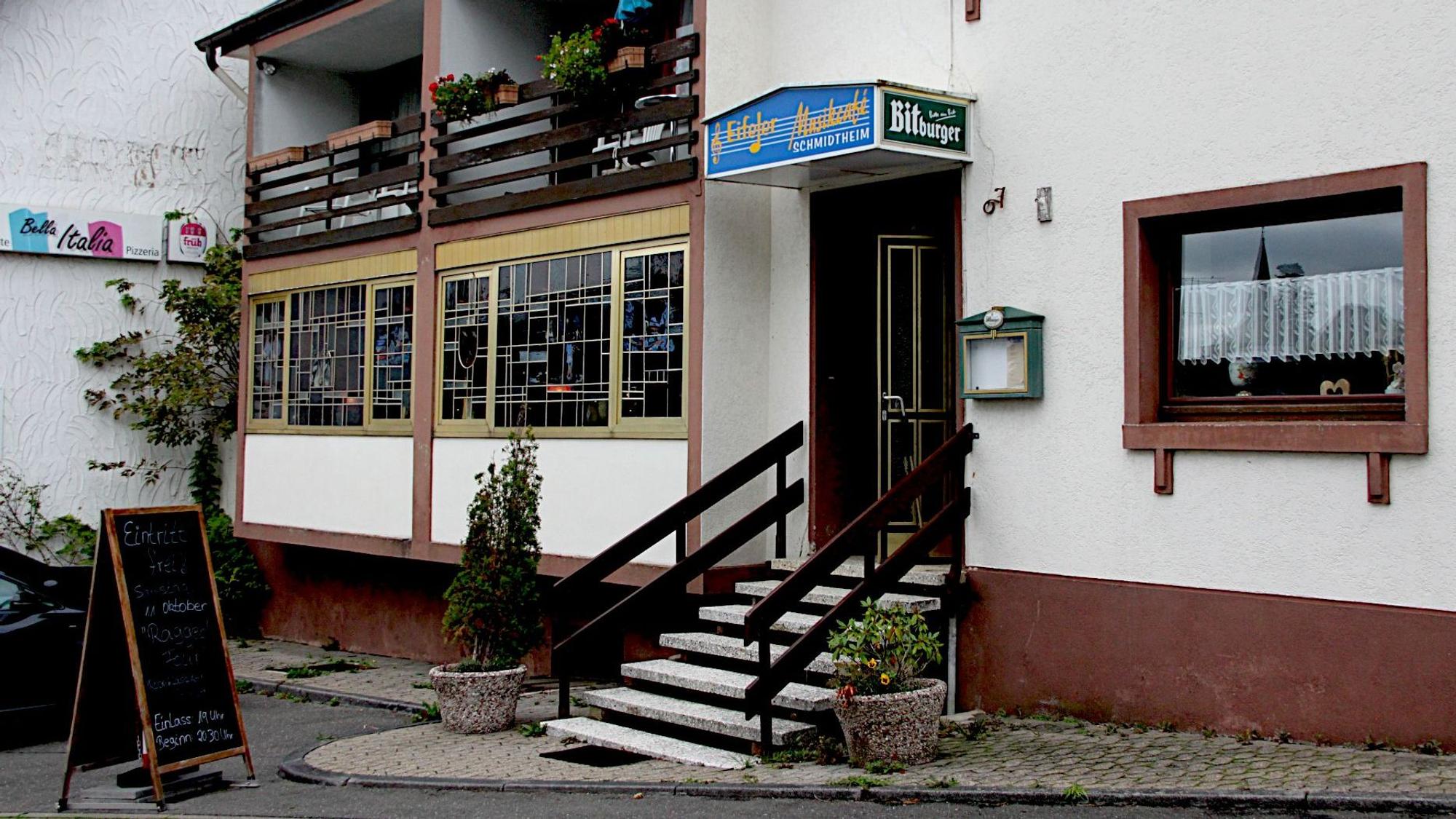 Eine Außenansicht, des „Eifeler Musikcafés“ in Schmidtheim, davor steht eine Klapptafel, auf der für das nächste Event geworben wird.
