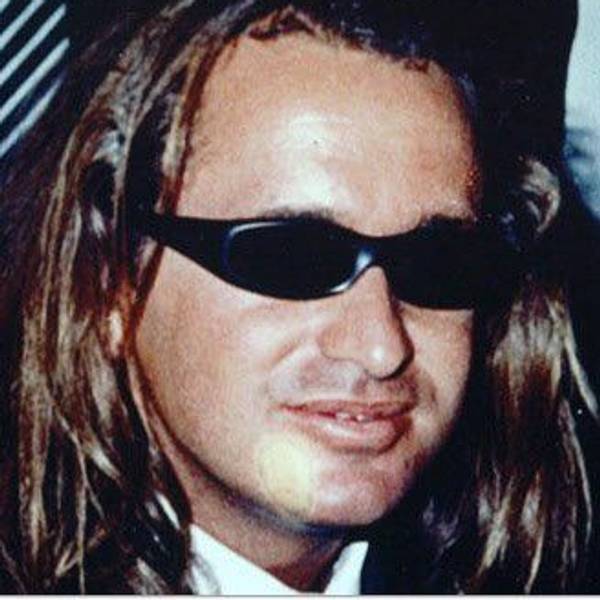 Ein Mann mit langen Haaren trägt eine Sonnenbrille.