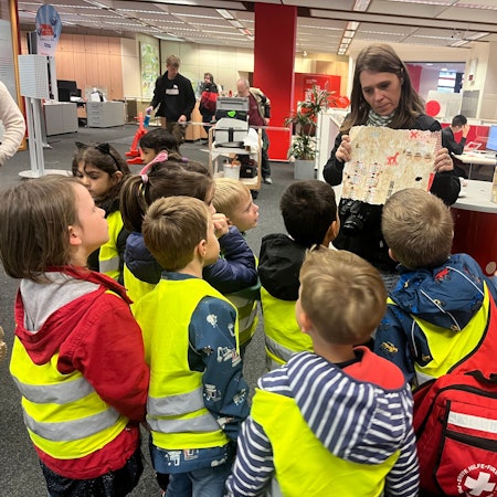Die Adlergruppe des katholischen Kindergartens St. Patricius besuchte die Kreissparkasse in Eitorf, Erzieherin Jenny Schwarz zeigt die Schatzkarte.