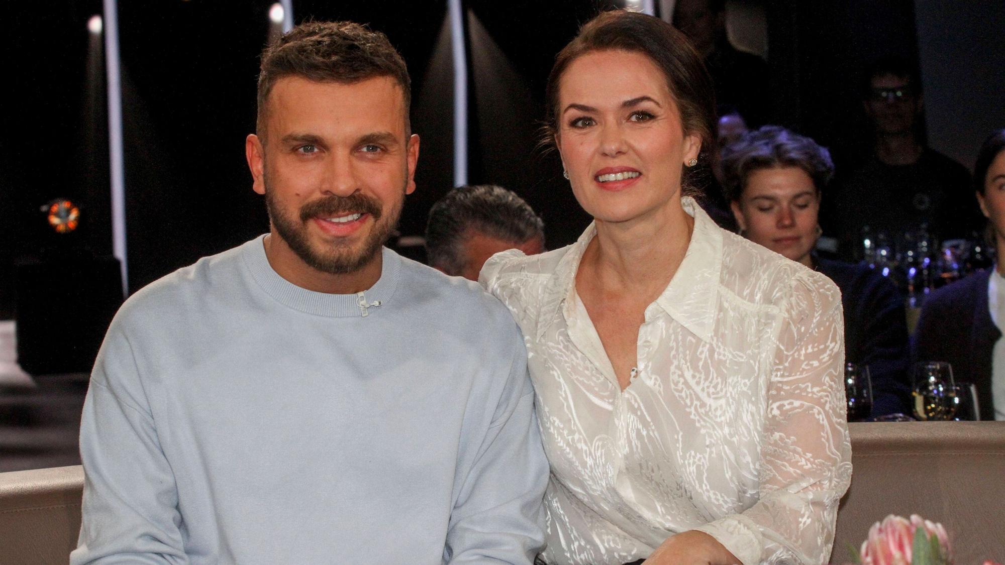 Edin Hasanović und eine Frau lächeln zusammen bei einem TV-Auftritt