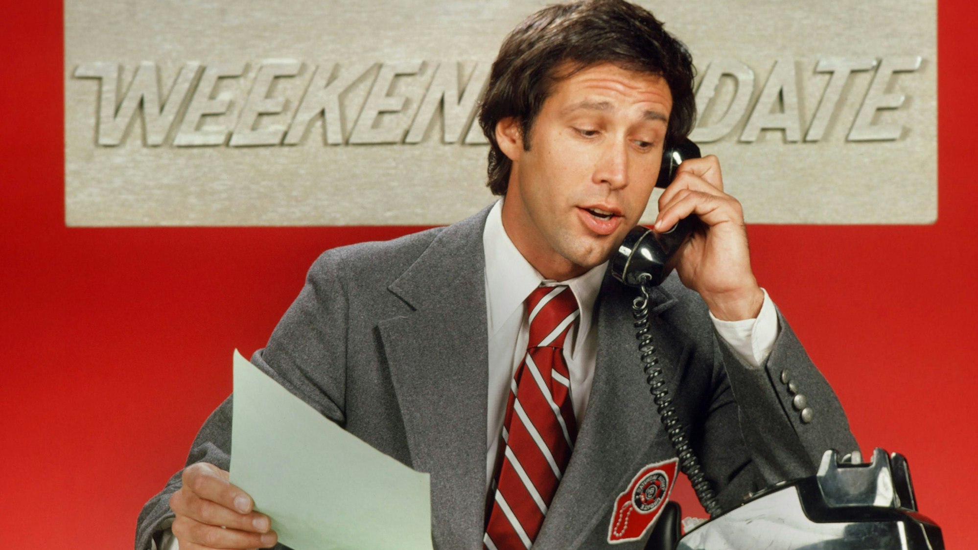 Chevy Chase telefoniert als Moderator des „Weekend Update“-Formats