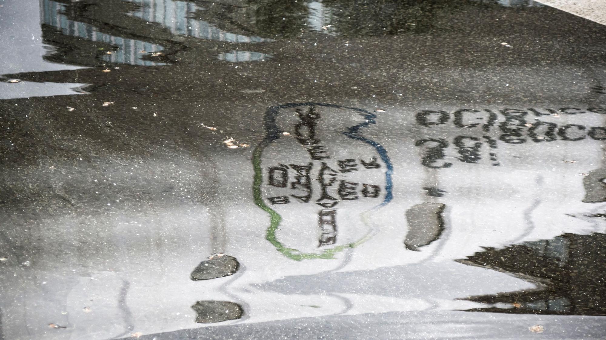 Die Bayer-Werbung an der Röhre über der B8 spiegelt sich in einer Pfütze.