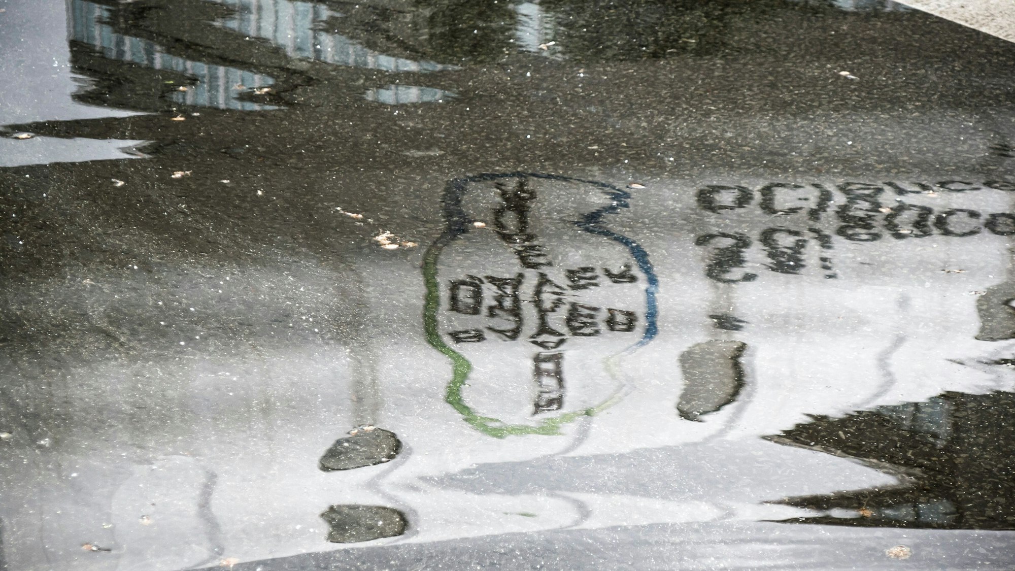 Die Bayer-Werbung an der Röhre über der B8 spiegelt sich in einer Pfütze.