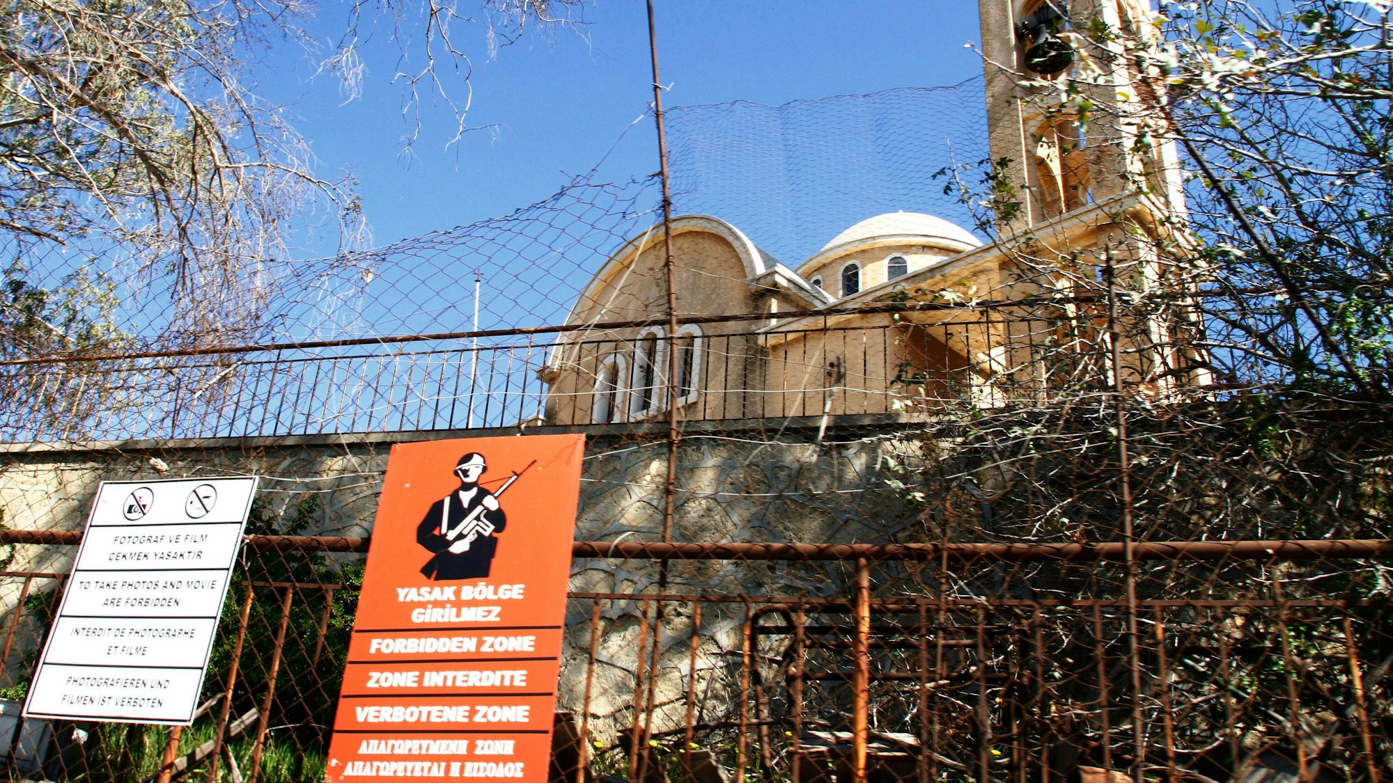 Eine verlassene christlich-orthodoxe Kirche ist hinter einem militärischen Schild zu sehen.