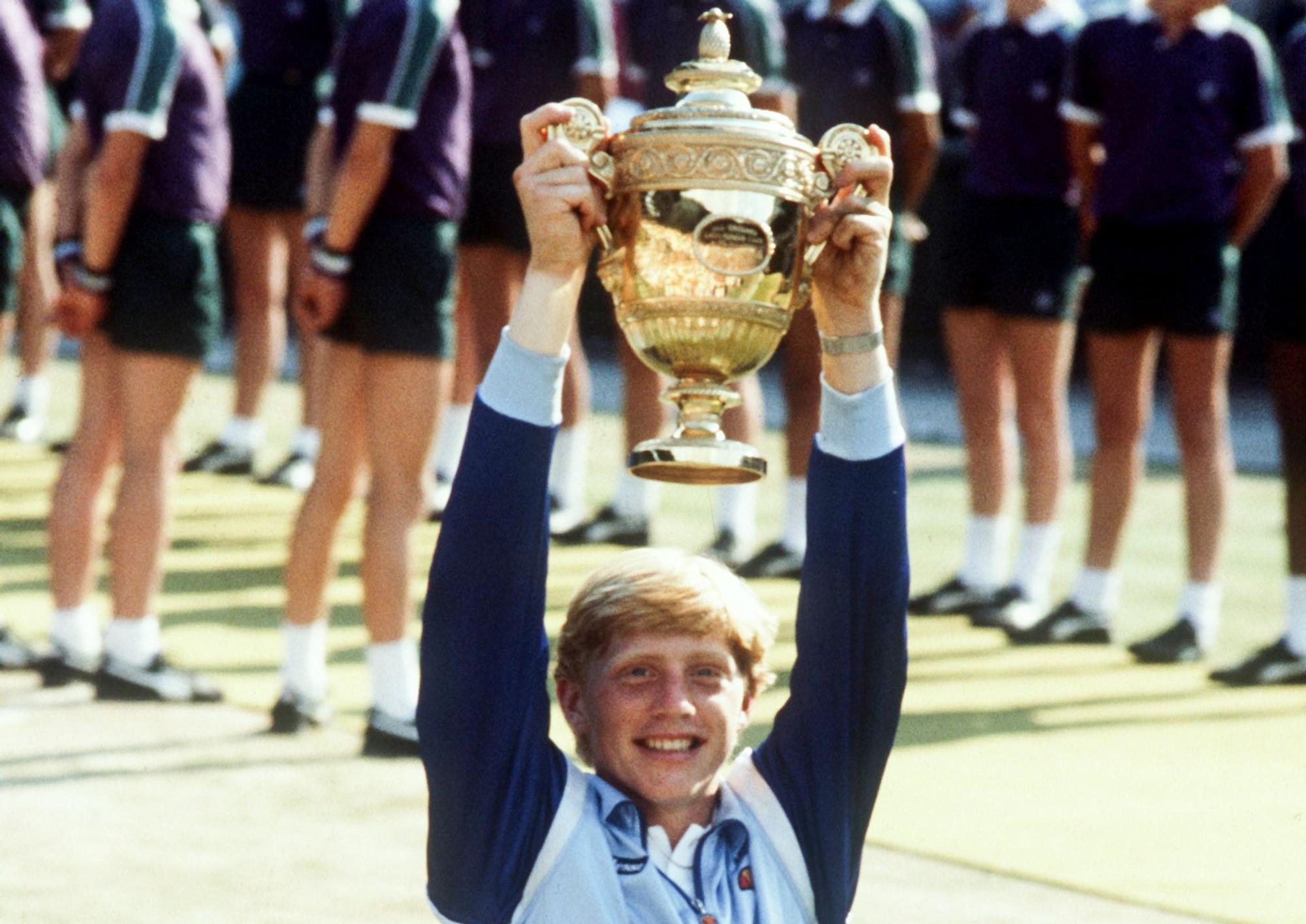 07.07.1985, Großbritannien, Wimbledon: Der erst 17-jährige deutsche Tennisspieler Boris Becker strahlt und hebt triumphierend den Siegerpokal empor, der ihm am 07.07.1985 nach seinem Erfolg über den US-Amerikaner Kevin Curren im Wimbledon-Finale überreicht worden ist.