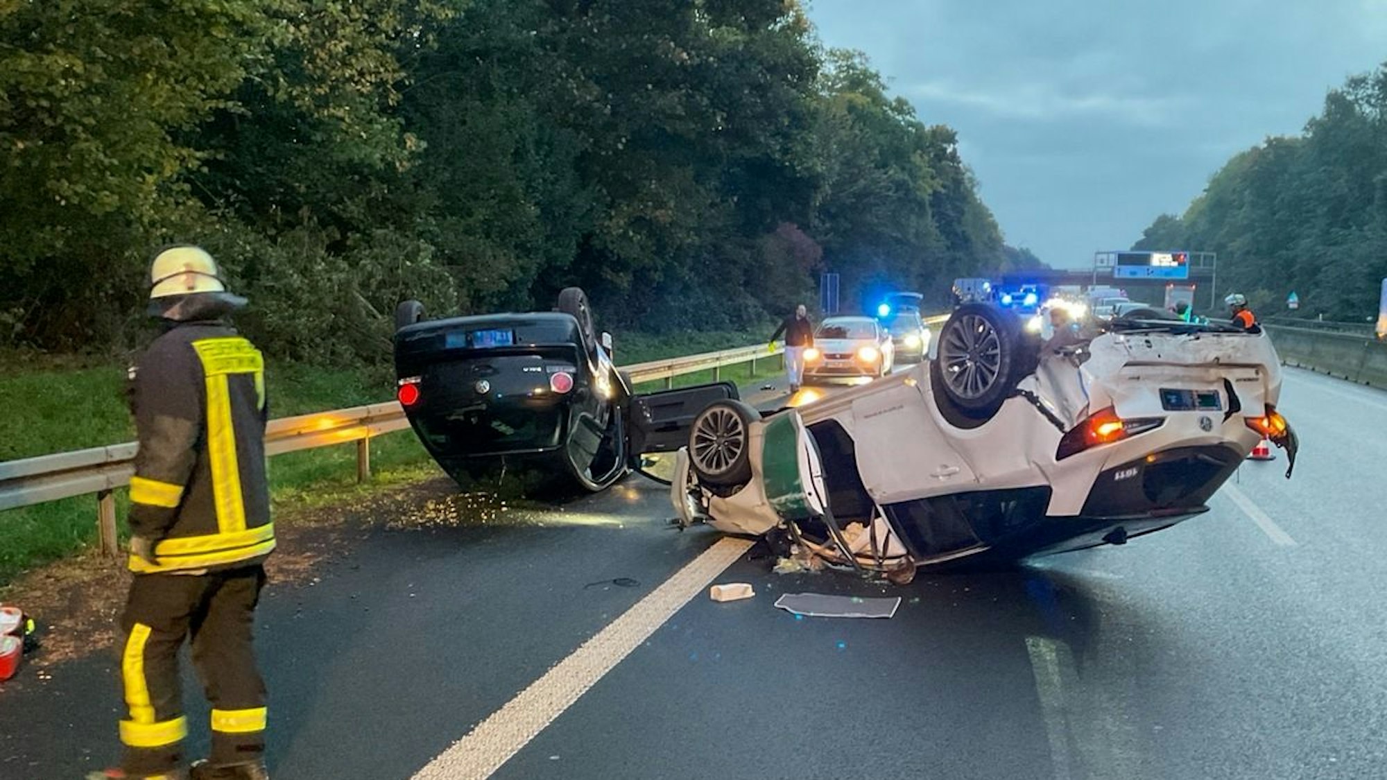 Zwei auf dem Dach liegende Unfallfahrzeuge auf der Autobahn A42.