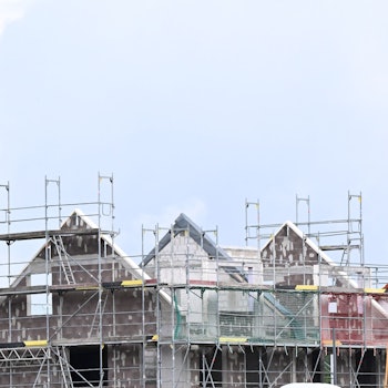 Das Bild zeigt ein im Bau befindliches Haus. Ein Baukran steht davor.