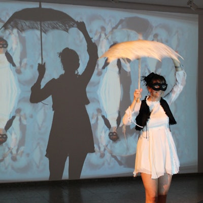 Das Foto zeigt eine Künstlerin vor einer Video-Installation.