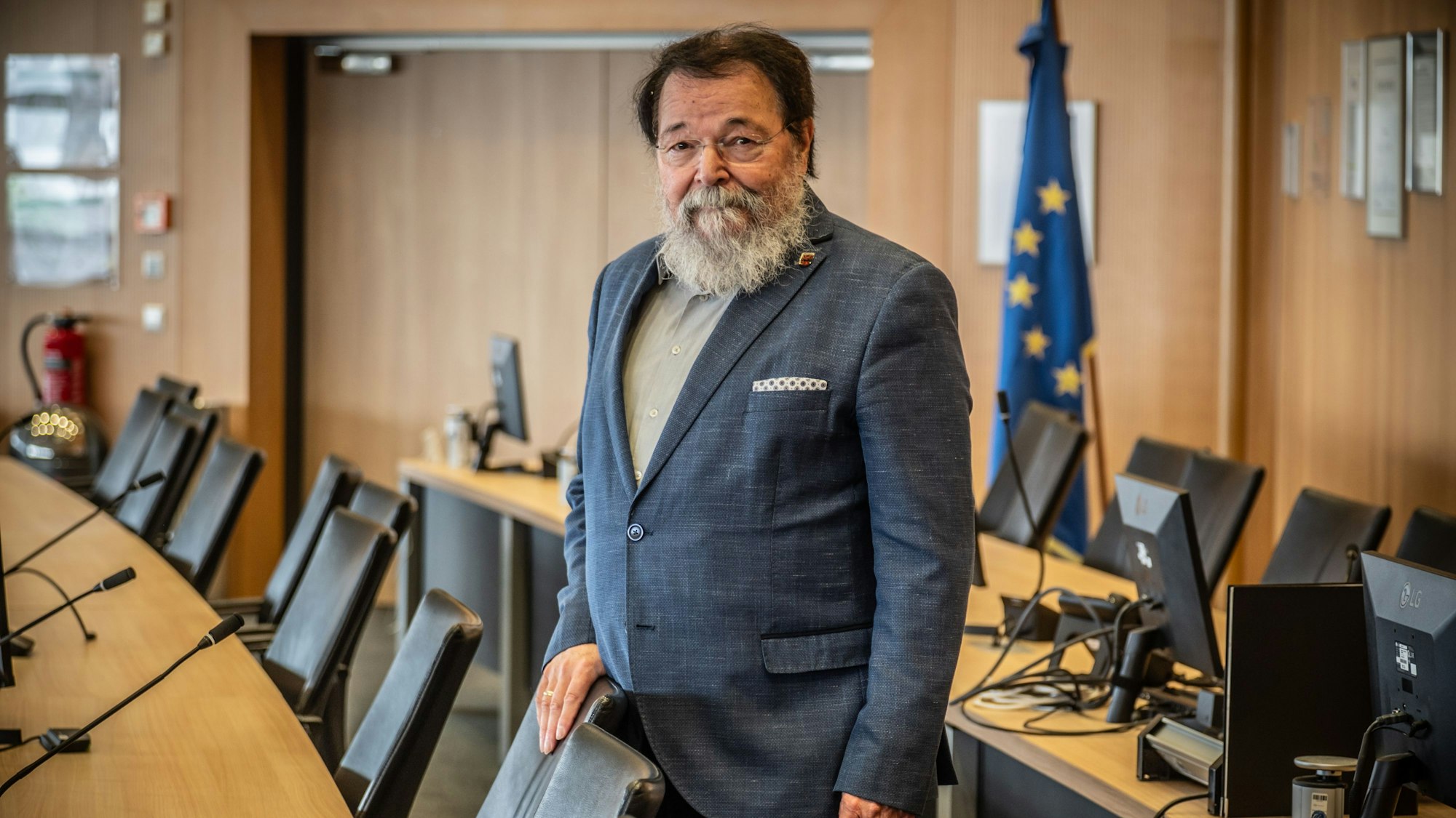 Bernhard Marewski steht im Leverkusener Ratssaal an seinem Stuhl. Er ist Ratsmitglied seit 1989 und Bürgermeister seit 2015.