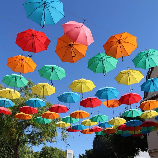 Bunte Regenschirme hängen über einer Straße.