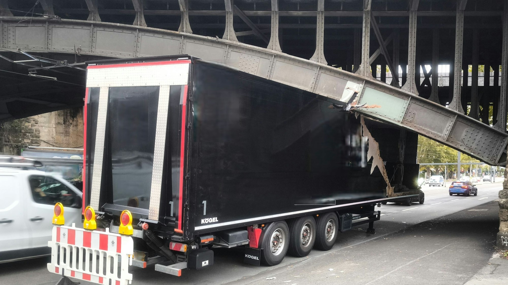 Ein Lkw klemmt unter einer Brücke, sein Auflieger ist eingedrückt.
