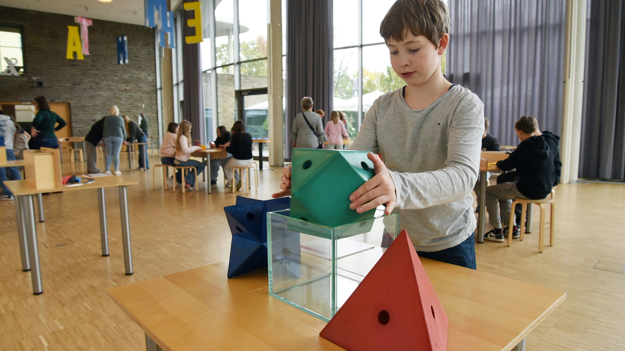 Was passt ineinander und was nicht? Paul (12) ist versunken in ein Experiment in der neuen Mitmach-Ausstellung rund um die Mathematik in Nümbrecht.
