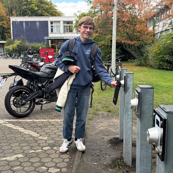 Auf dem Bild ist ein Schüler mit seinem Smartphone zu sehen.