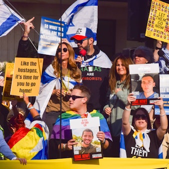 Menschen demonstrieren mit Schildern und israelischen Flaggen für die Freilassung der Geiseln in Gaza