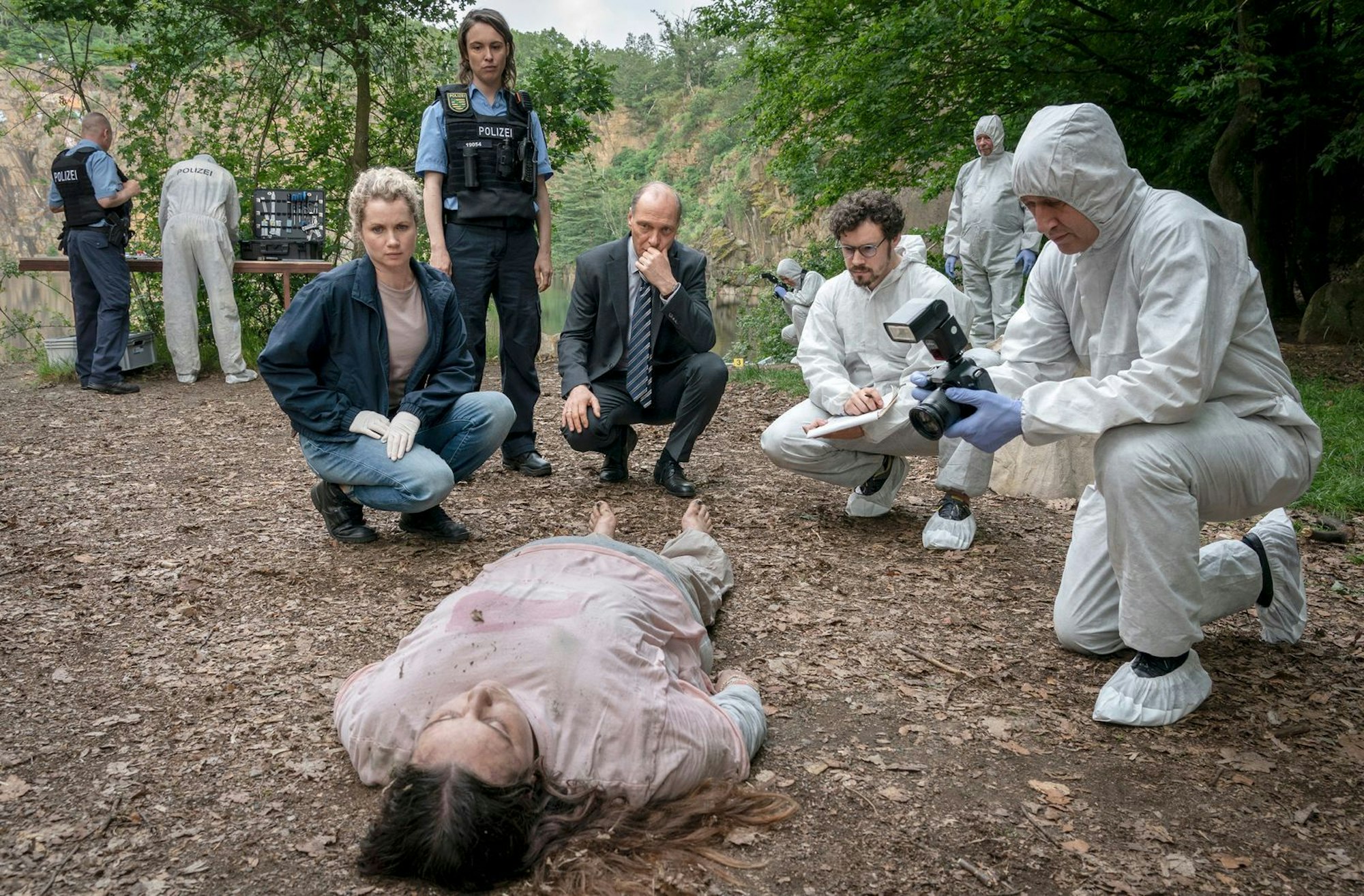 Eine 16-Jährige, die in einem Kinderheim lebte, wurde tot aus einem See geborgen. Leonie Winkler (Cornelia Gröschel, links), Polizistin Antje (Victoria Schulz), Peter Schnabel (Martin Brambach, dritter von links) und Dr. Himpe (Ron Helbig) inspizieren die Tote Lilly-Marie Reuter (Dilara Aylin Ziem). (Bild: MDR/MadeFor Film/Steffen Junghans)