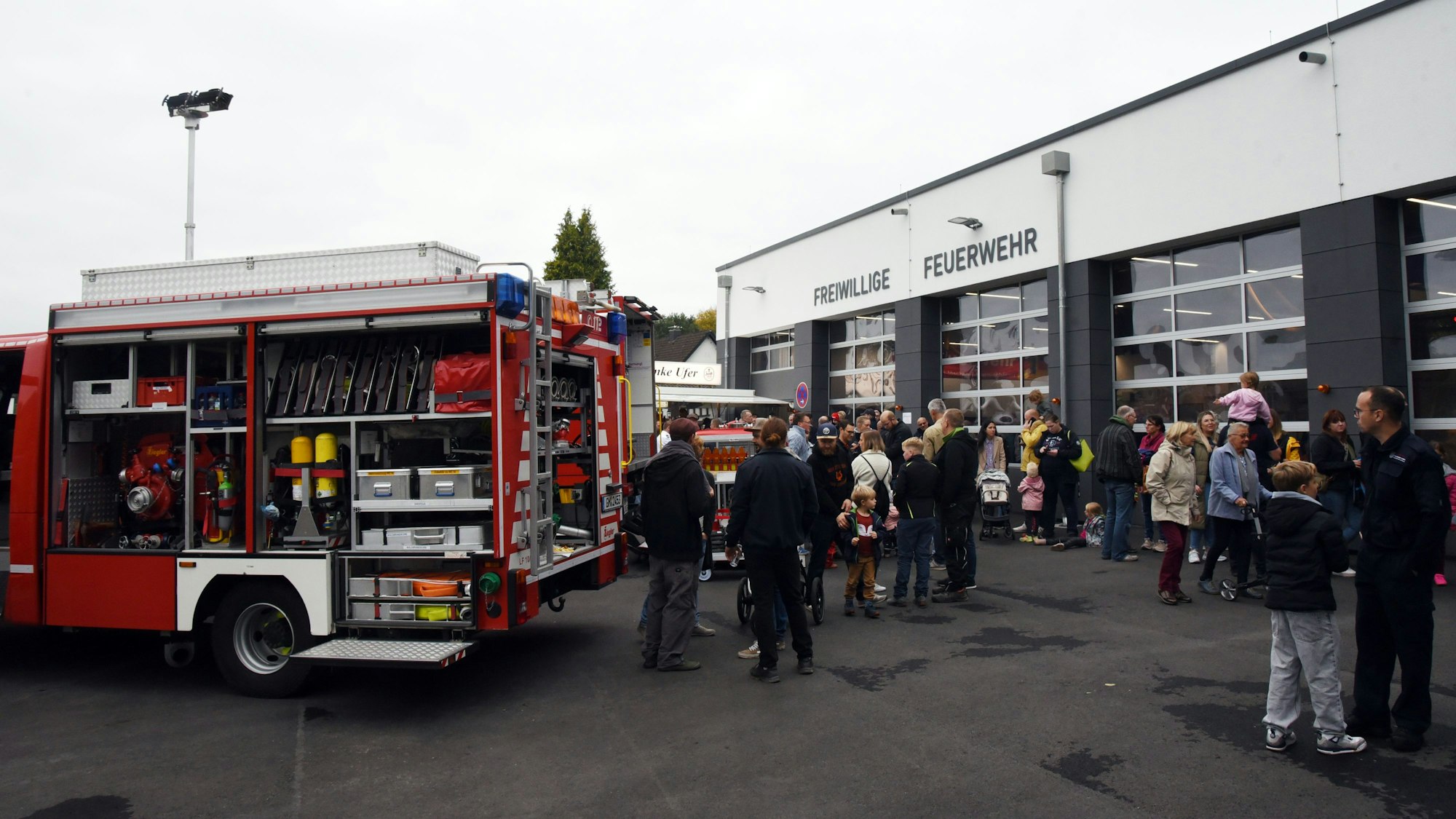 Das Foto zeigt die neue Feuerwache und davor viele Besucher.