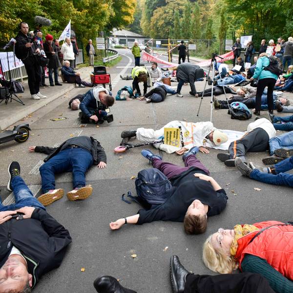 Das Bild zeigt Personen/ Demonstranten, die auf der Straße liegen.
