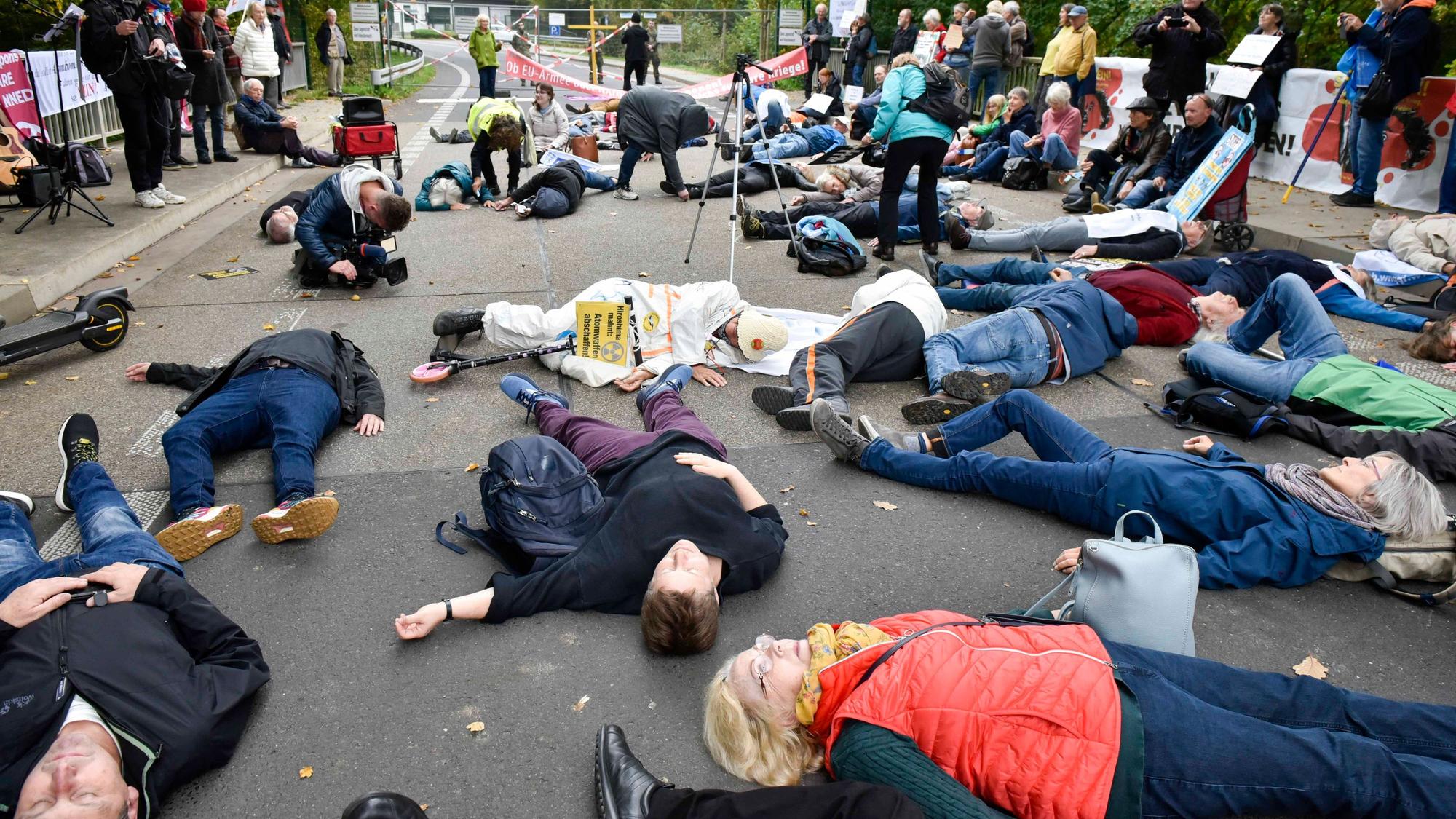 Das Bild zeigt Personen/ Demonstranten, die auf der Straße liegen.