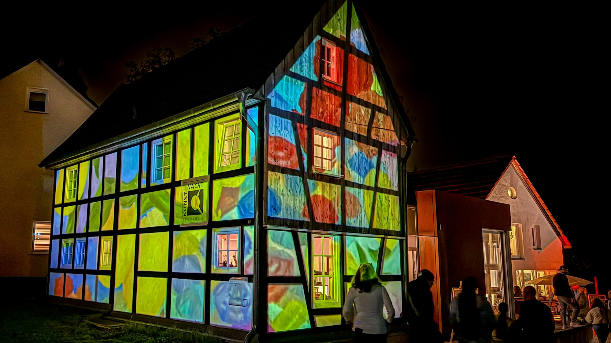 Ein Fachwerkhaus erstrahlt mit Projektionen in bunten Farben.