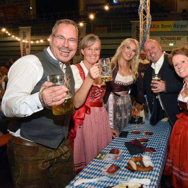 Das Foto zeigt lachende Männer und Frauen in bayerischer Tracht und mit Bierkrügen in der Hand.