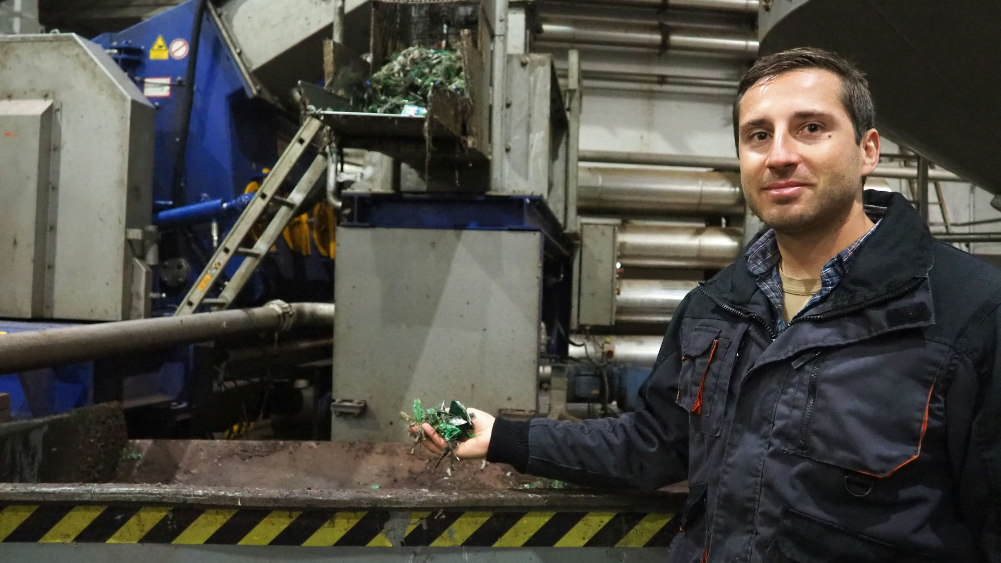 Maximilian Kipp zeigt die Kunststoffreste, die aus den zerkleinerten Lebensmitteln aussortiert worden sind.