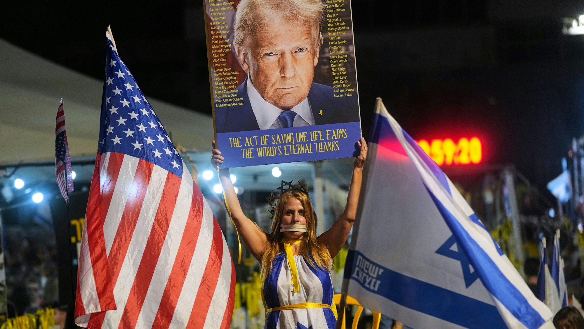 Eine Frau hält ein Schild mit einem Bild des US-Präsidenten Trump während einer Kundgebung zur Unterstützung der von der Hamas entführten Geiseln auf einem Platz in Isreal.