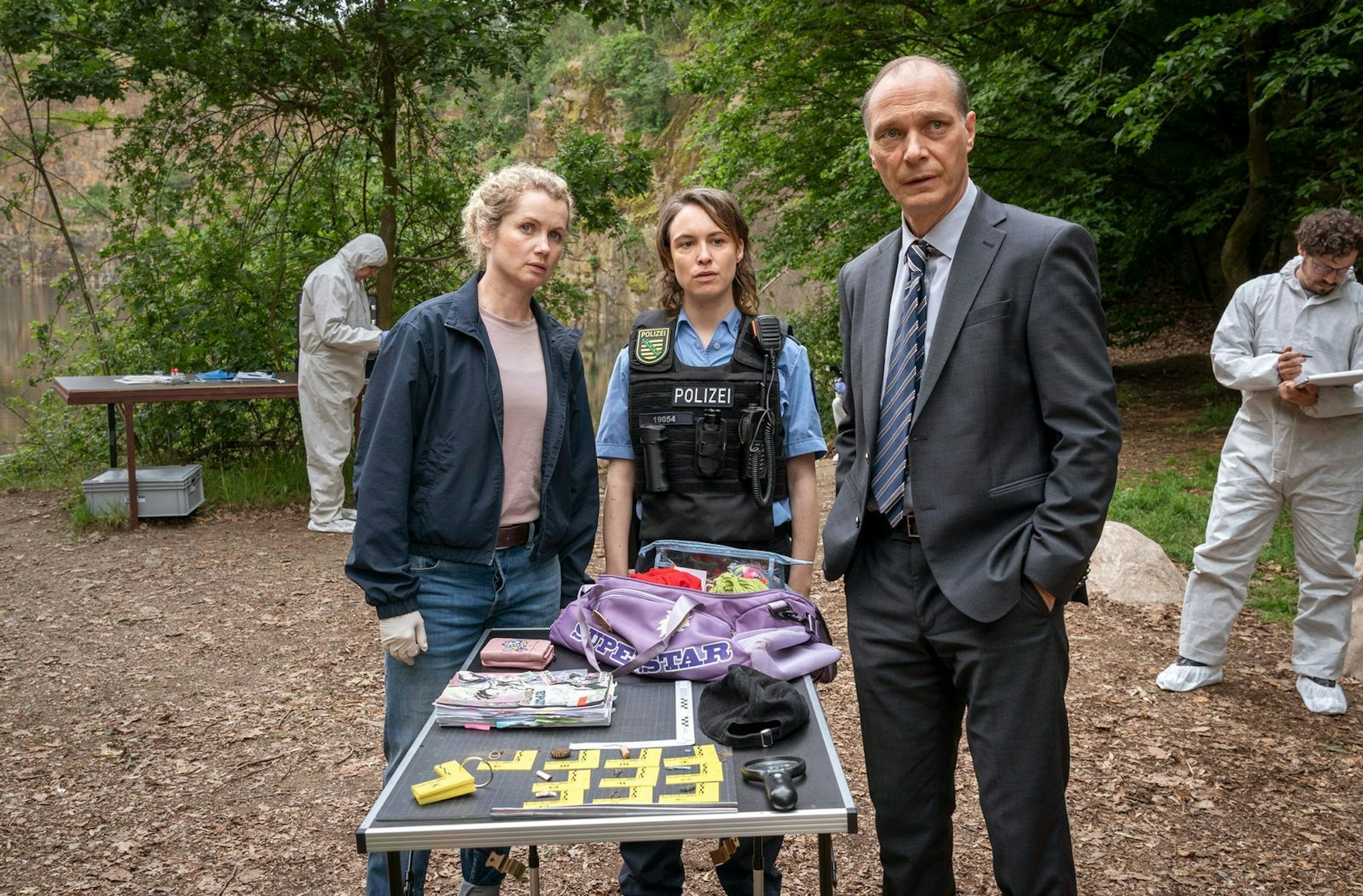 Diese Dinge trug das tote Mädchen bei sich: Leonie Winkler (Cornelia Gröschel, links), Polizistin Antje (Victoria Schulz) und Peter Schnabel (Martin Brambach) untersuchen die Tasche von Lilly-Marie. (Bild: MDR/MadeFor Film/Steffen Junghans)