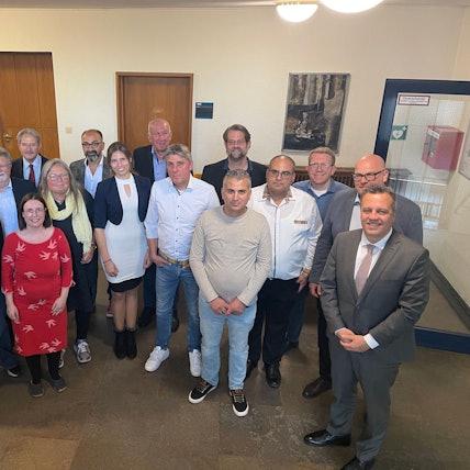 Knapp 20 Frauen und Männer haben sich zu einem Gruppenbild aufgestellt.