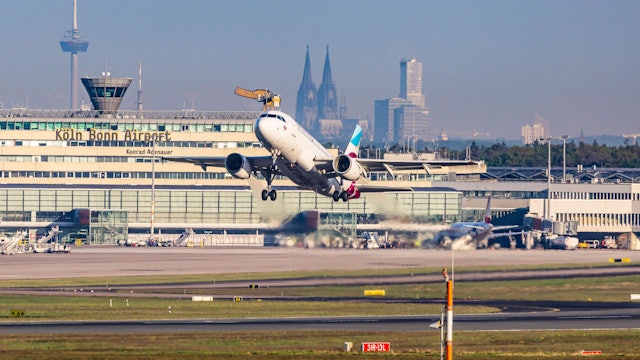 Am Flughafen Köln/Bonn hebt eine Eurowings-Maschine ab. Im Hintergrund sind Dom und Colonius zu sehen.