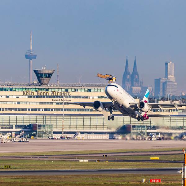 Am Flughafen Köln/Bonn hebt eine Eurowings-Maschine ab. Im Hintergrund sind Dom und Colonius zu sehen.