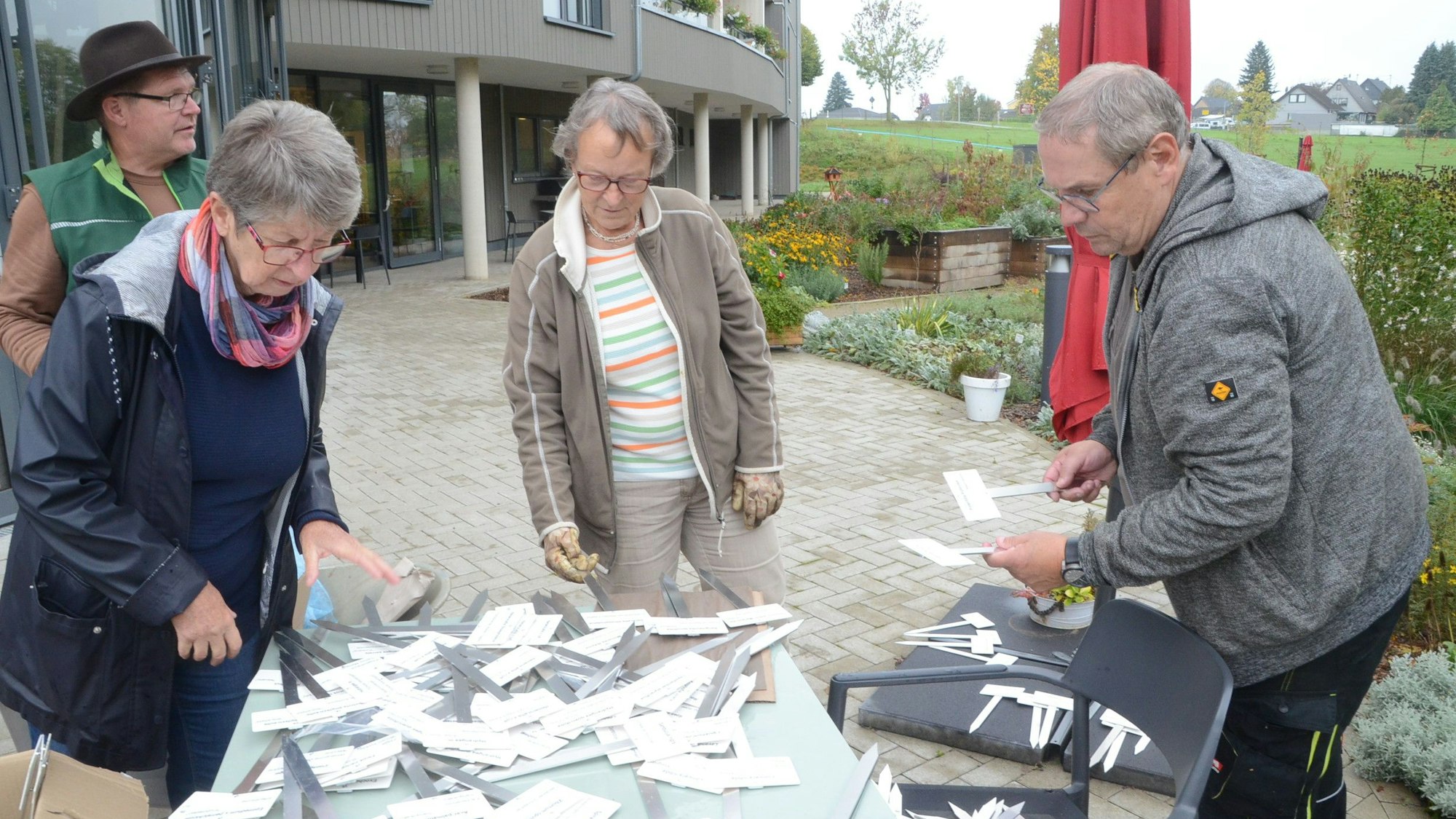 Männer und Frauen an einem Tisch mit Steckschildern.