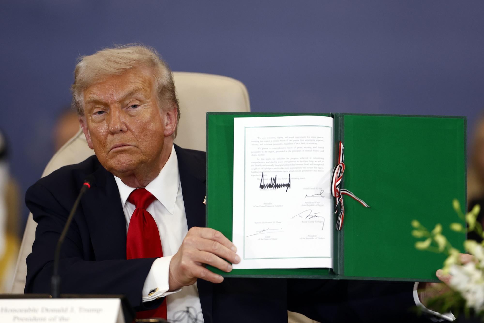 US-Präsident Donald Trump posiert mit dem unterzeichneten Abkommen beim «Gipfel für den Frieden». Foto: Yoan Valat/Pool EPA/AP/dpa