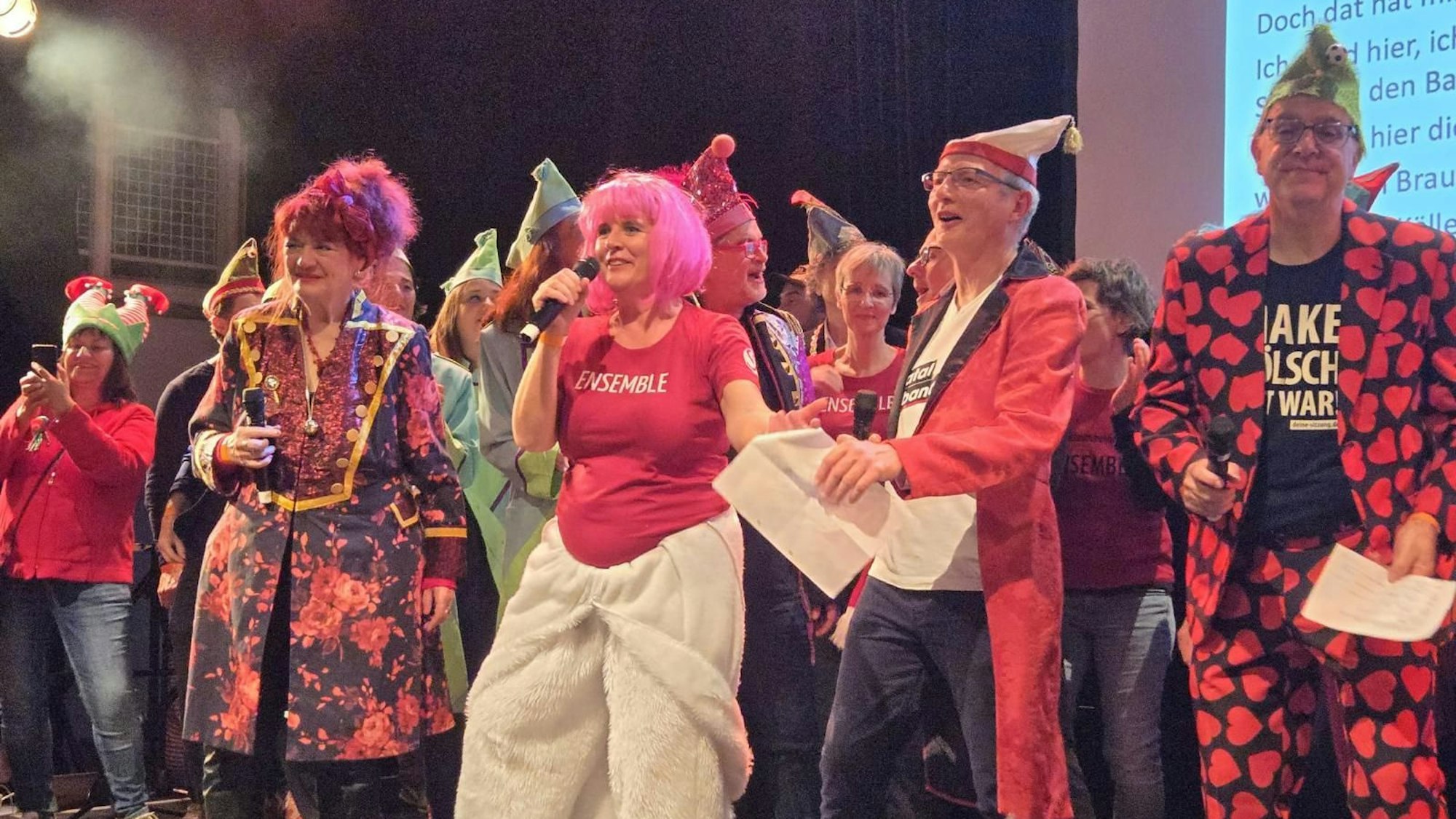 Verkleidete Personen stehen mit Mikrofonen auf der Bühne