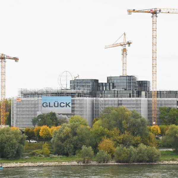 Das Gebäude der DEVK Versicherung in Köln ist teilweise eingerüstet. Daneben stehen Baukräne.