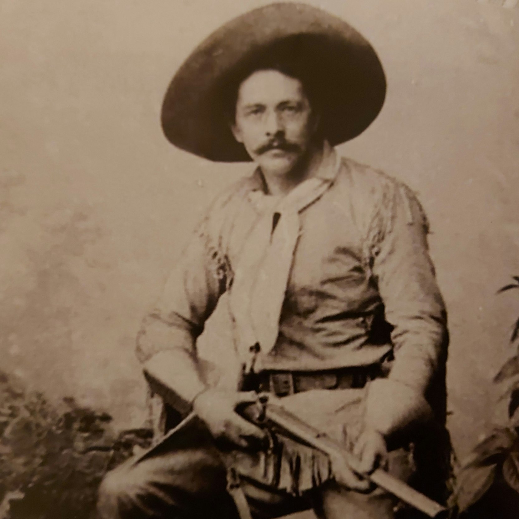 Ein Mann im Cowboyanzug hält ein Gewehr in der Hand