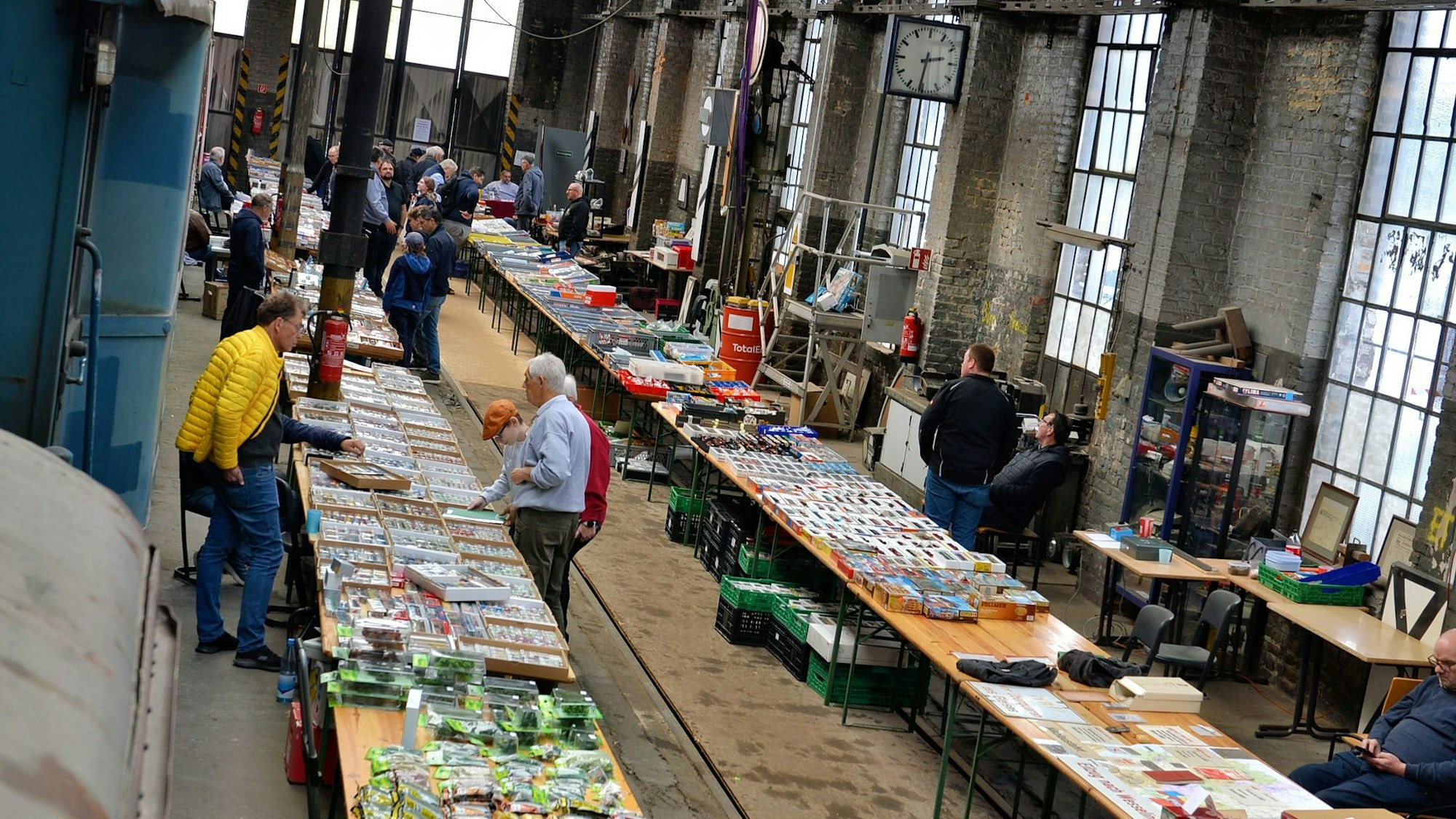 Im alten Lokschuppen in Euskirchen sind zahlreiche Biertische aufgebaut, auf denen Modelleisenbahnen und Zubehör angeboten werden.