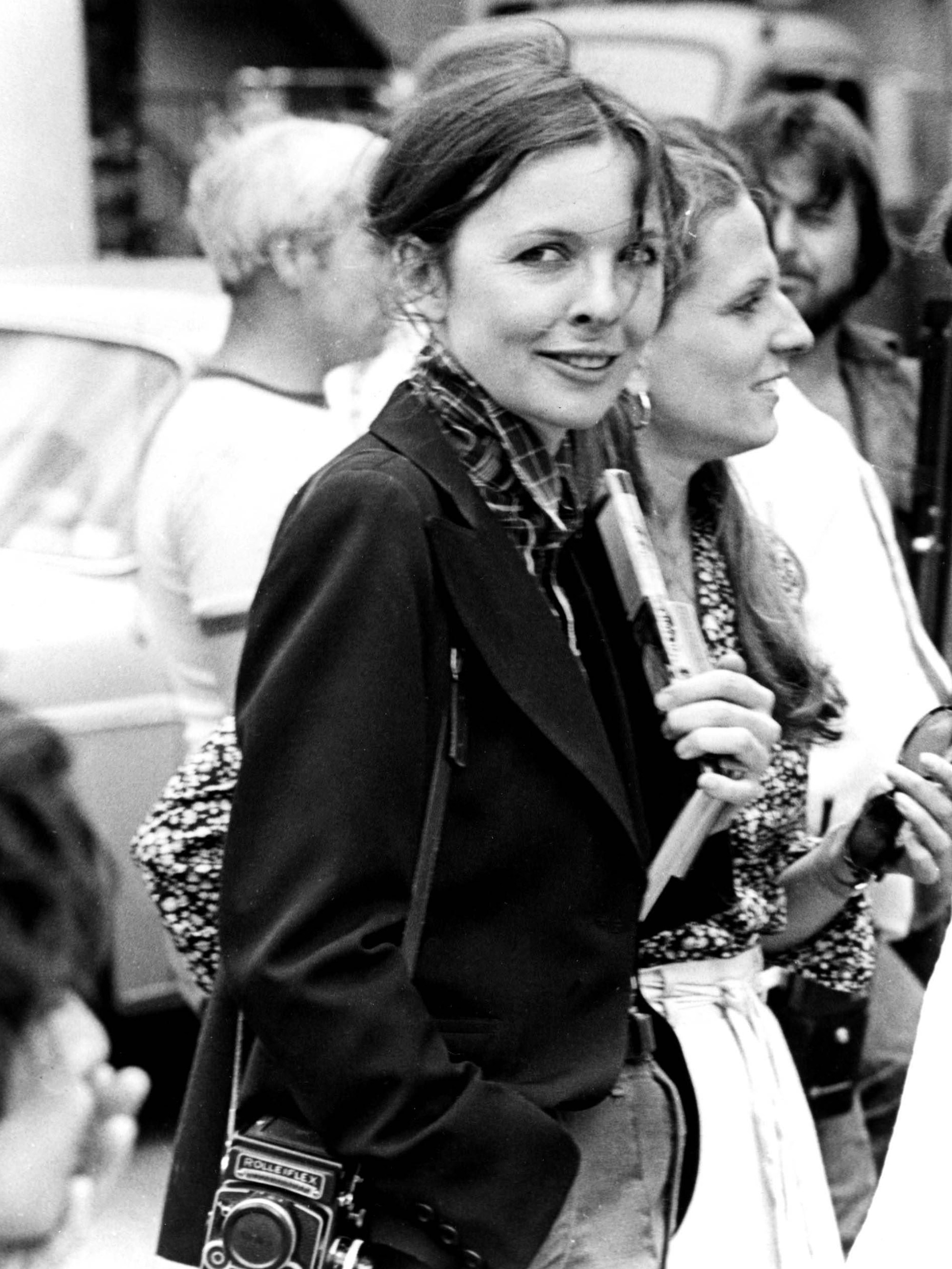 Diane Keaton trägt eine Fotokamera über der Schulter.