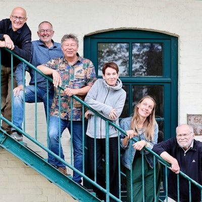Menschen stehen auf iner Treppe.