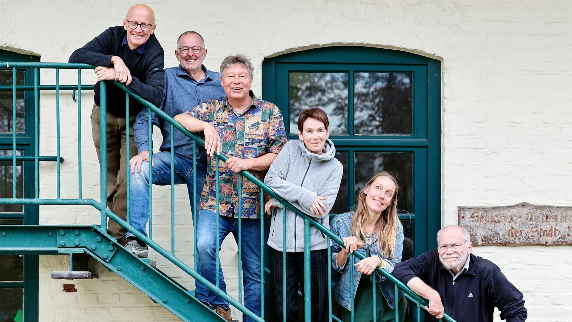 Menschen stehen auf iner Treppe.