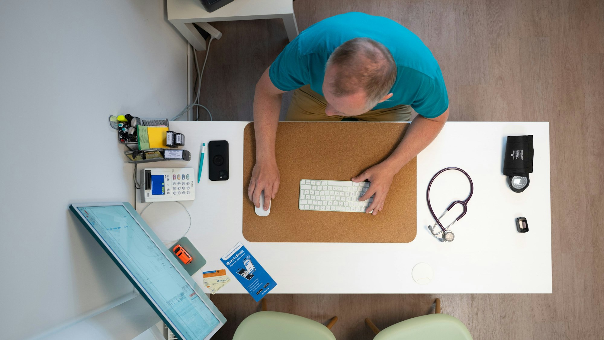 ILLUSTRATION - 27.05.2025, Sachsen, Dresden: Ein Hausarzt sitzt in einem Sprechzimmer seiner Hausarztpraxis an einem Schreibtisch neben einem Stethoskop und arbeitet am Computer. (zu dpa: «Wie startet der Vollbetrieb der E-Patientenakten?») Foto: Sebastian Kahnert/dpa +++ dpa-Bildfunk +++