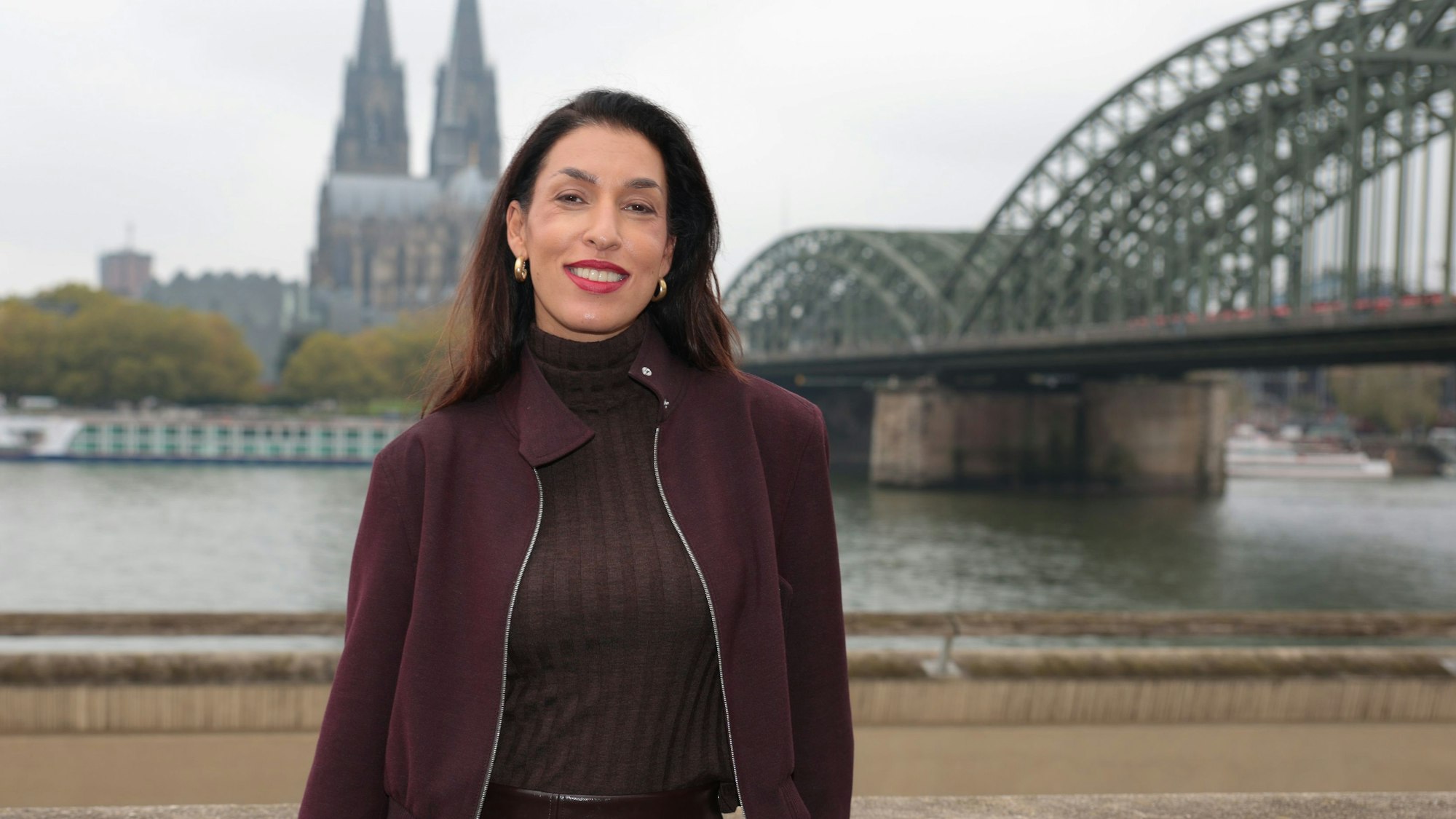 Tijen Onaran beim Interview in Köln, im Hintergrund der Rhein, Dom und die Hohenzollernbrücke