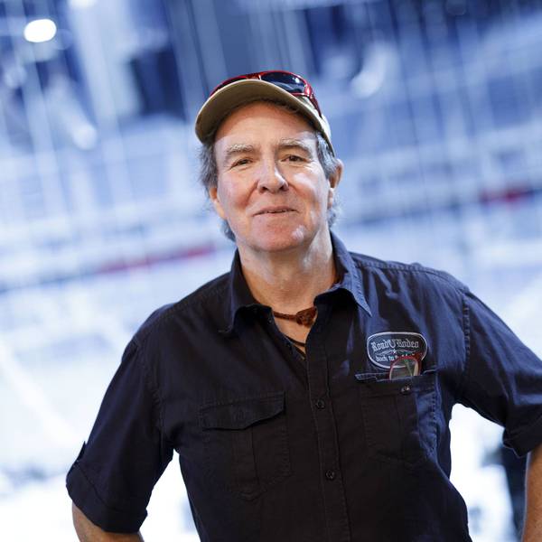 Sänger Peter Horn lächelt mit Kappe, Hemd und „Roadie Rodeo“ Patch vor blauem Hintergrund.