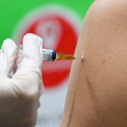 Eine Frau erhält in einer Apotheke eine Grippeschutzimpfung.