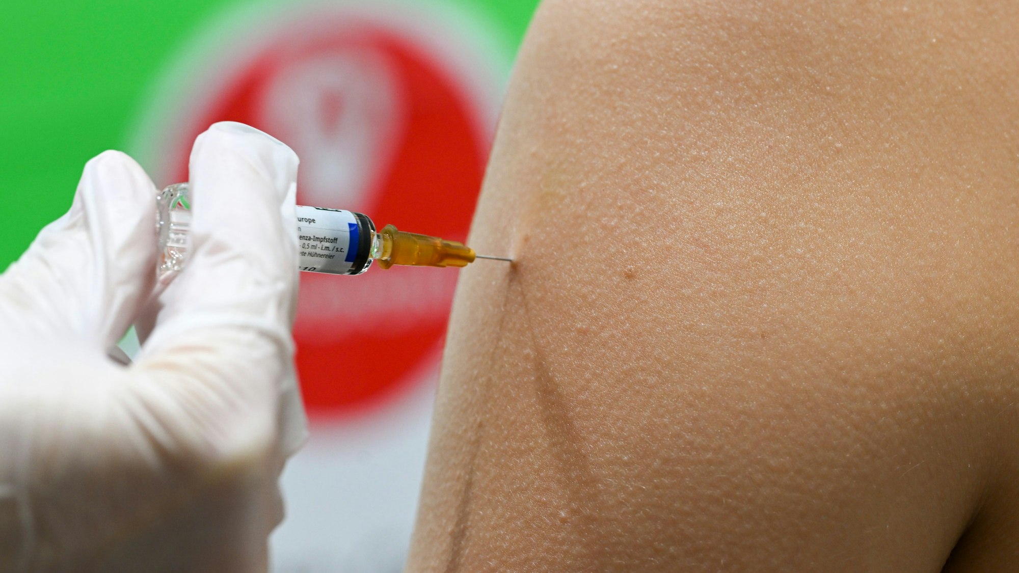 Eine Frau erhält in einer Apotheke eine Grippeschutzimpfung.