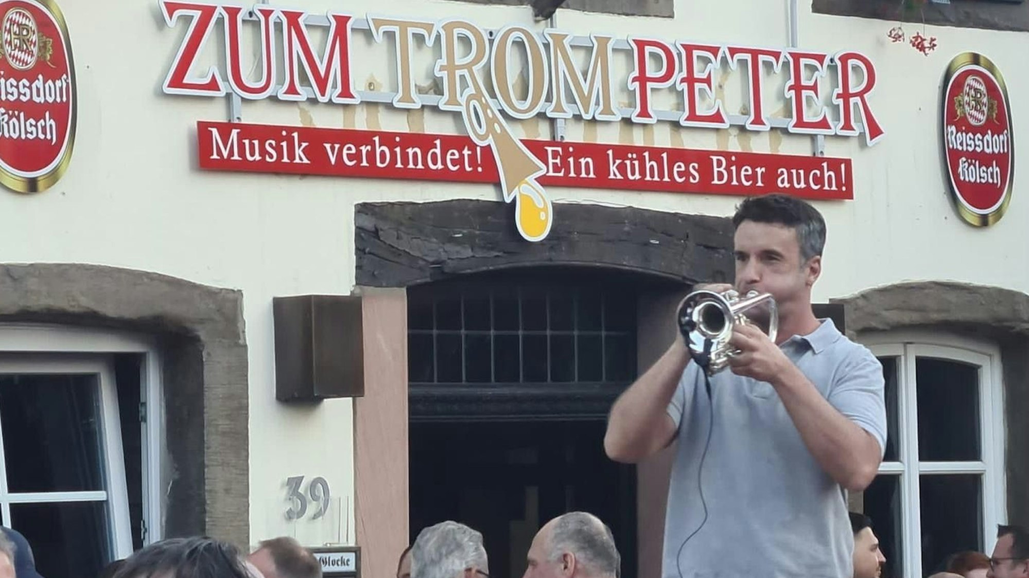 Das Foto zeigt einen Trompetenspieler vor der Gaststätte „Zum Trompeter“.