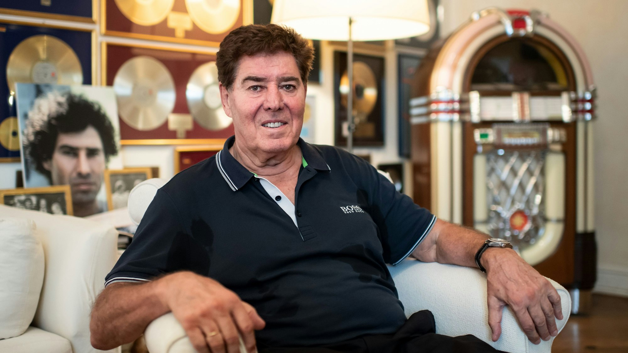 Jack White, Musikproduzent, sitzt in seiner Wohnung in Berlin-Charlottenburg, an der Wand hängen zahlreiche Goldene Schallplatten.