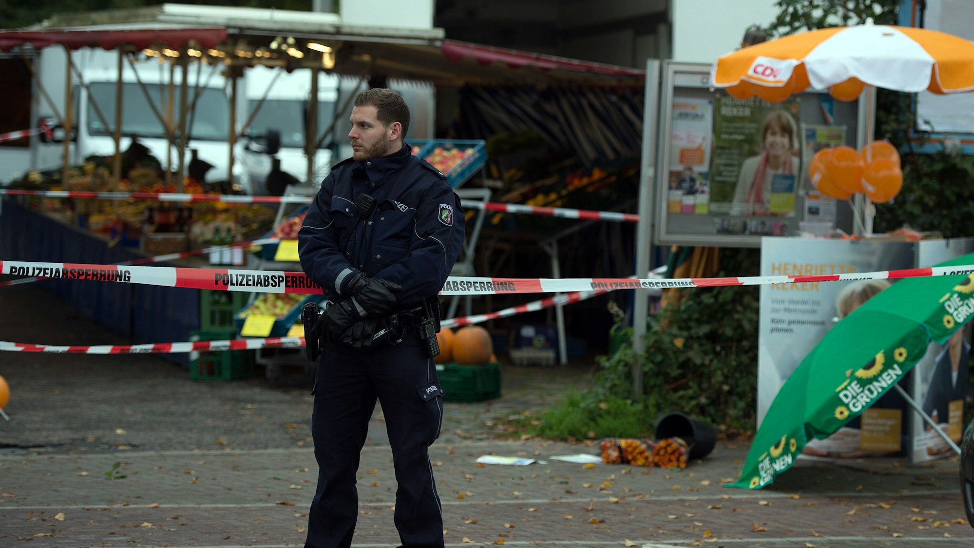 Ein Polizist sichert am 17.10.2015 in Köln (Nordrhein-Westfalen) einen Tatort. Die Kölner Oberbürgermeisterkandidatin Henriette Reker ist einen Tag vor der Wahl bei einer Messerattacke in Köln verletzt worden. Der Angriff auf die parteilose Kandidatin ereignete sich bei einem Wahlkampftermin im Stadtteil Braunsfeld. Foto: Federico Gambarini/dpa ++ +++ dpa-Bildfunk +++